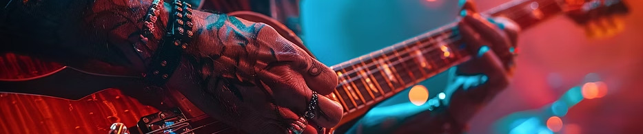 Hands on a red guitar under stage lights